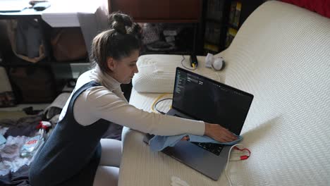 mujer limpiando su portátil en casa