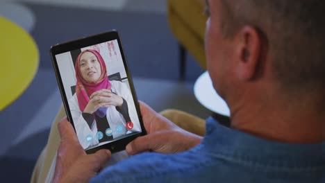 senior man having a video chat on his digital tablet at home