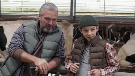 father and son farmers in a cow barn