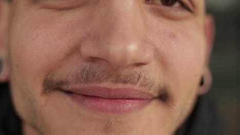 close up shot of smiling young man with thin moustaches