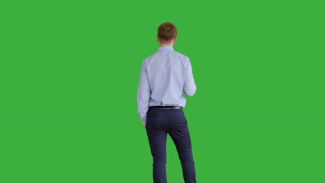 young handsome men acting in front of a green screen. blond hair, blue shirt and blue trousers. dancing, thinking, turning around and talking to the camera.