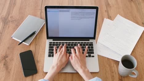 persona que trabaja en una computadora portátil en un escritorio