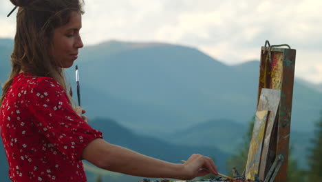 artista pintando una imagen vista de las montañas. pintor inspirado meditar colores de primer plano