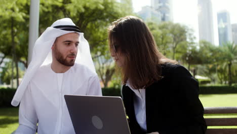 Man-and-woman-sitting-on-the-bench-of-a-park