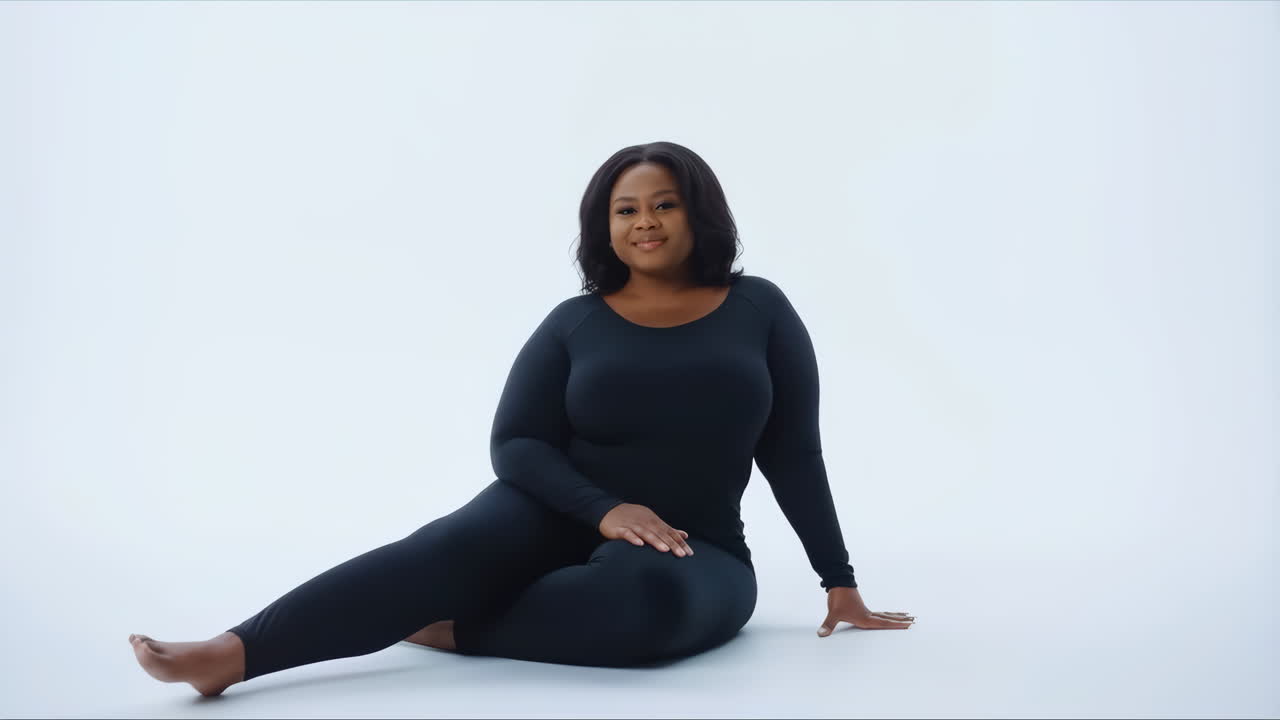 Donna afroamericana sicura di sé, seduta e sorridente in studio