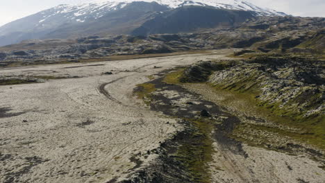 vuelo aéreo bajo sobre los áridos paisajes volcánicos de snaefellsnes en islandia