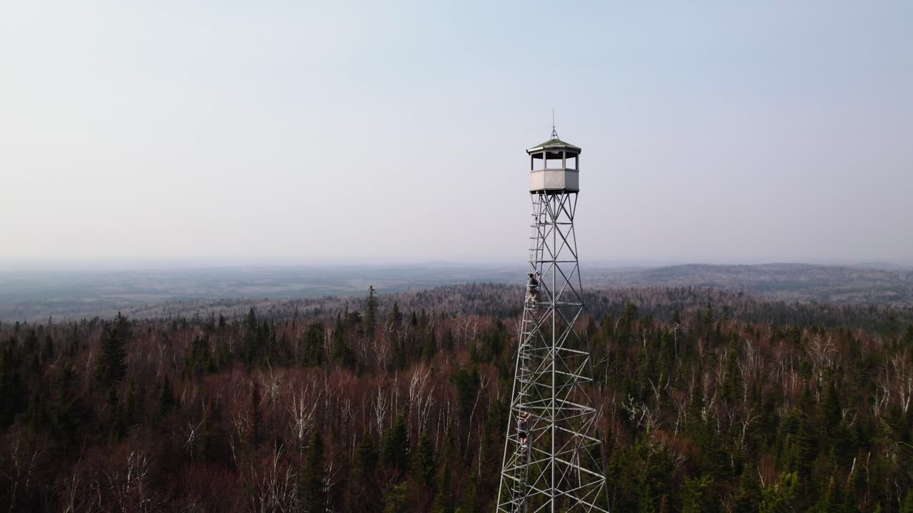 360 aerial épica de una torre de fuego en canadá con excursionistas subiendo a la cima