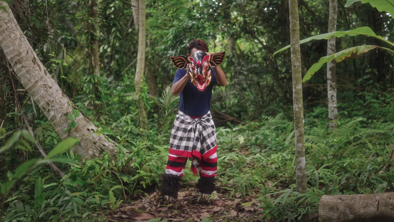 en el corazón de un bosque cerca del pueblo, un joven artista balinés realiza la tradicional danza barong bangkung