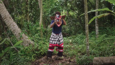 En-El-Corazón-De-Un-Bosque-Cerca-Del-Pueblo,-Un-Joven-Artista-Balinés-Interpreta-La-Tradicional-Danza-Barong-Bangkung.