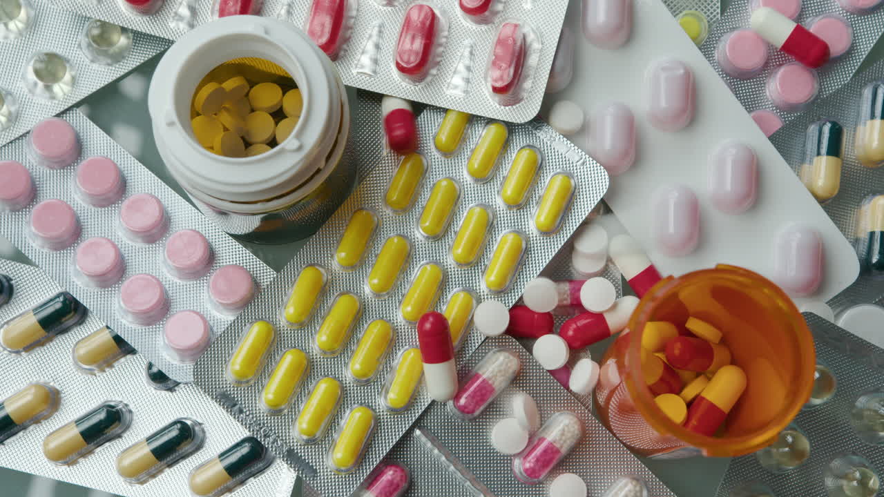 Close-Up of Pills and Tablets Falling Down on the Table with Medications