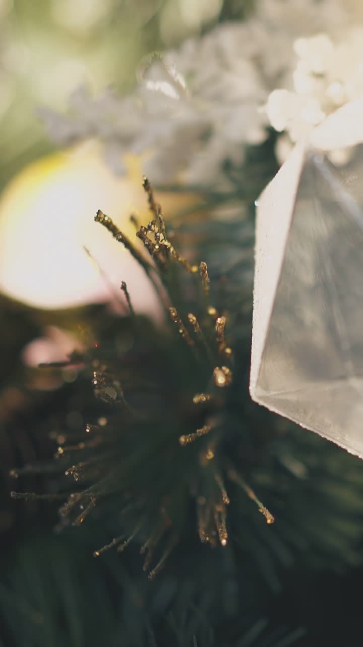 beautiful transparent ball as ice lump hangs on artificial Christmas tree branch at home extreme close view