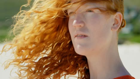 Woman-with-windswept-hair-standing-on-beach-4k