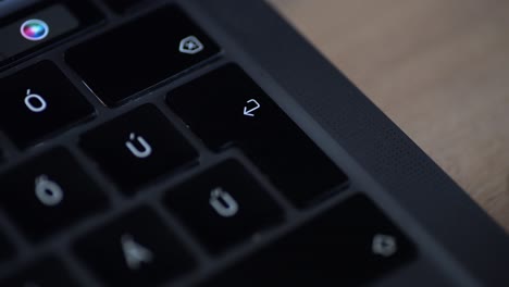a close-up video of a finger pressing the enter key on a laptop keyboard. the focus on the black keys and subtle lighting creates a professional and concentrated atmosphere