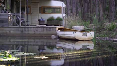 rowing boat on a lake docked at an isolated cabin in the forest