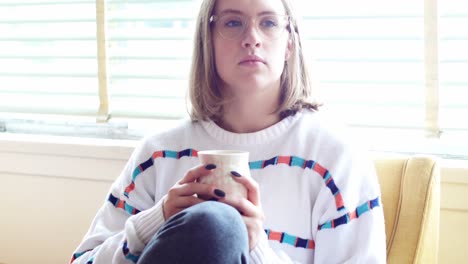 mujer pensativa tomando una taza de café