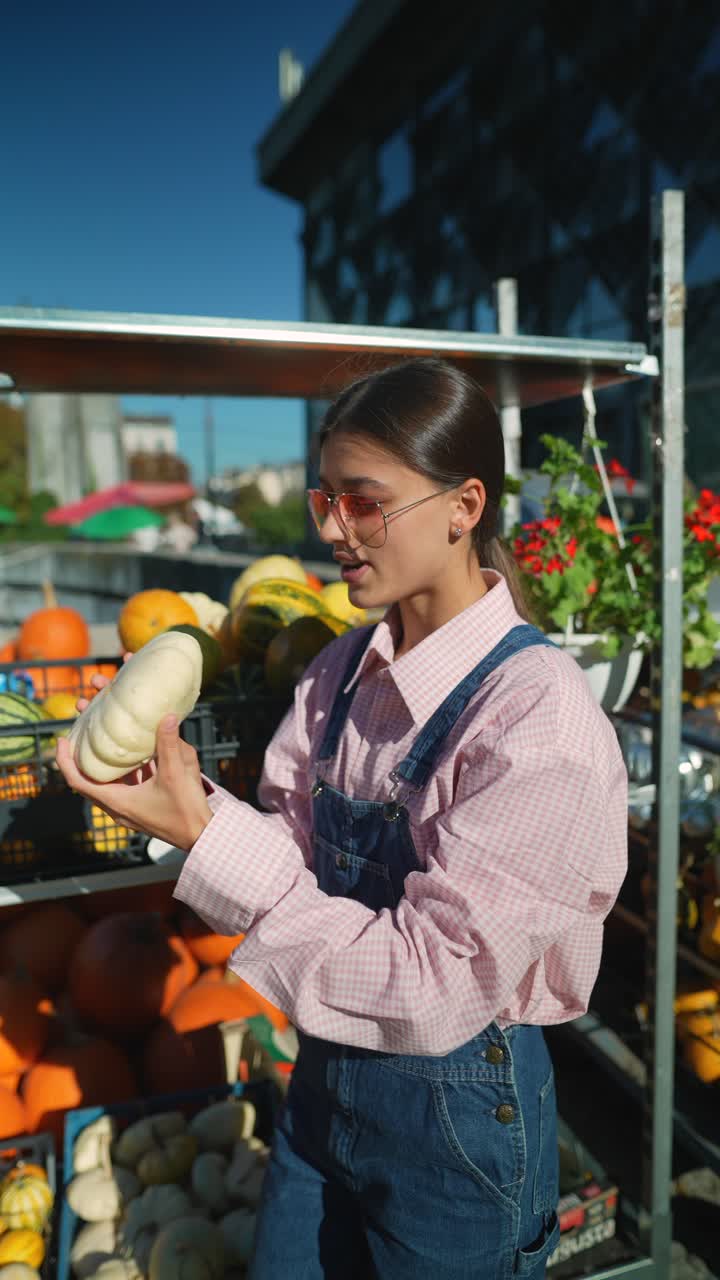 mujer comprando calabazas en un mercado al aire libre