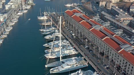 aerial tilt-up view of luxury yachts and sailboats docked at port of genova