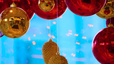 christmas and new year decoration. christmas big red balls on  background of luminous lanterns and gold garlands. holiday background. blinking garland. red baubles with lights twinkling close up.