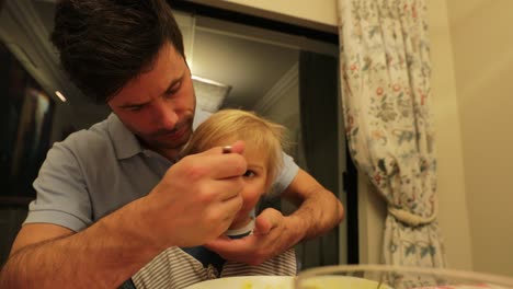 padre alimentando al bebé en casa en 4k. padre nutriendo al niño pequeño
