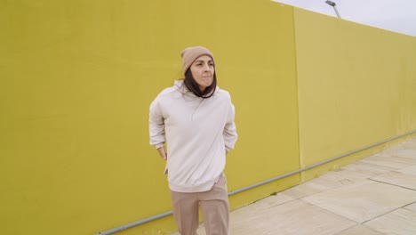 woman posing in front of yellow wall