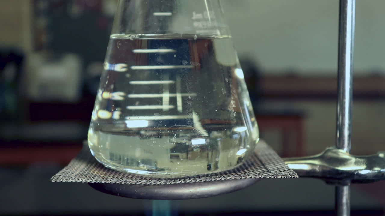 matraz erlenmyer que está siendo calentado por un mechero bunsen no queda condensación, ondas de calor visibles en el matraz, burbujas formándose rápidamente