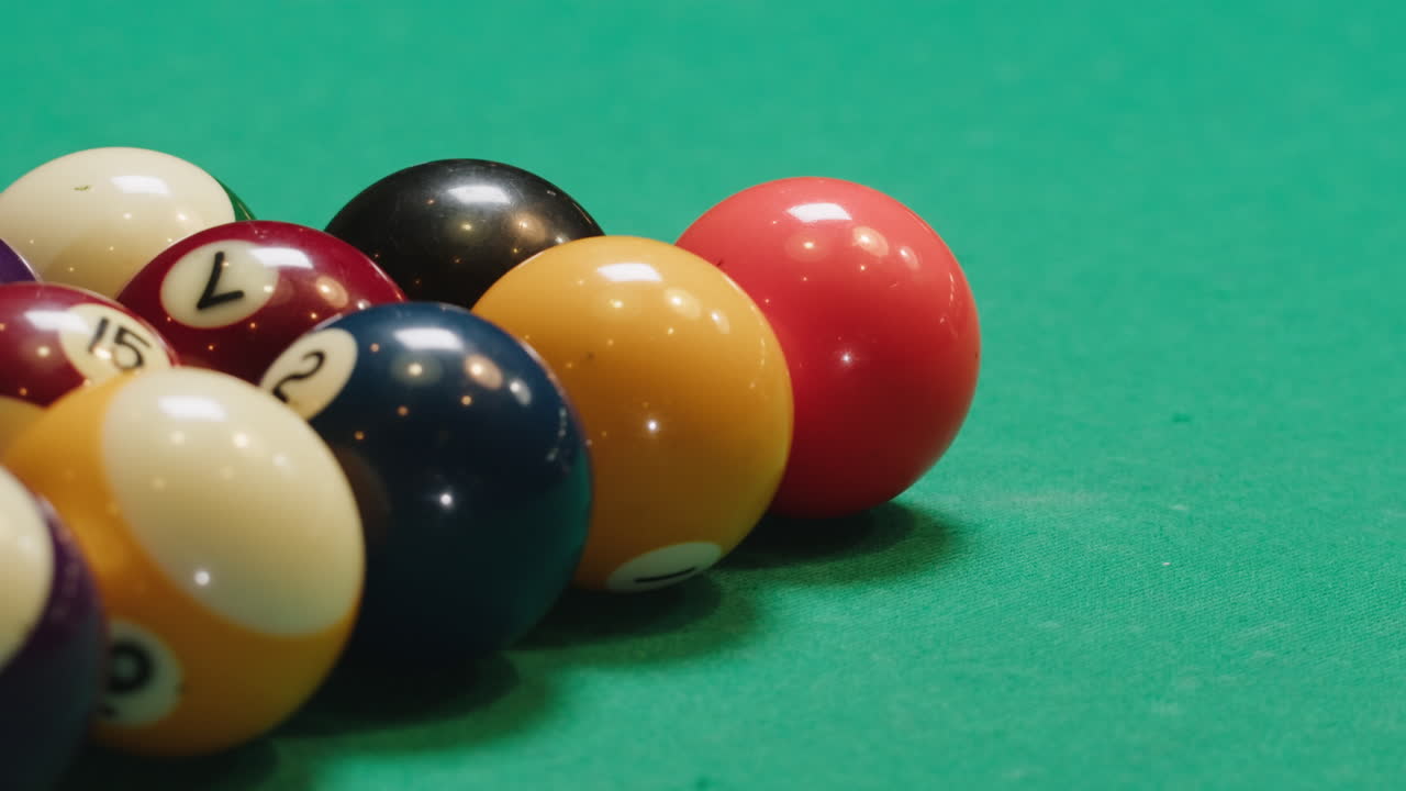 Young man breaking colorful pool balls with cue on green billiards table for start to play. American pool, poule game. Billiard balls with numbers on a pool table. Billiards team sport.