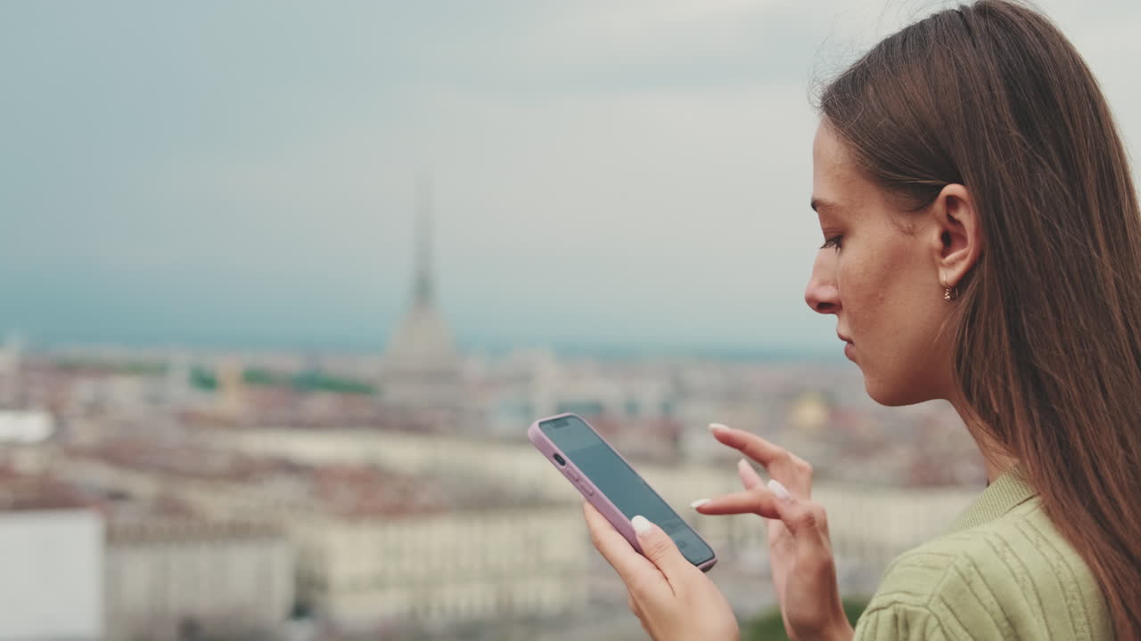 Young Woman Using Smartphone Outdoors with City Skyline in Background