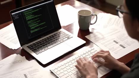 a focused programmer engages with code on a laptop surrounded by documents and a coffee mug, symbolizing the blend of creativity and analysis in software development