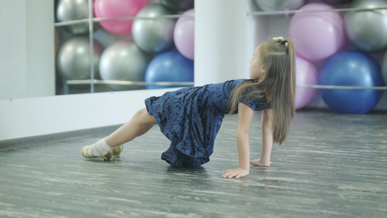 Menina se alongando no chão em estúdio de dança