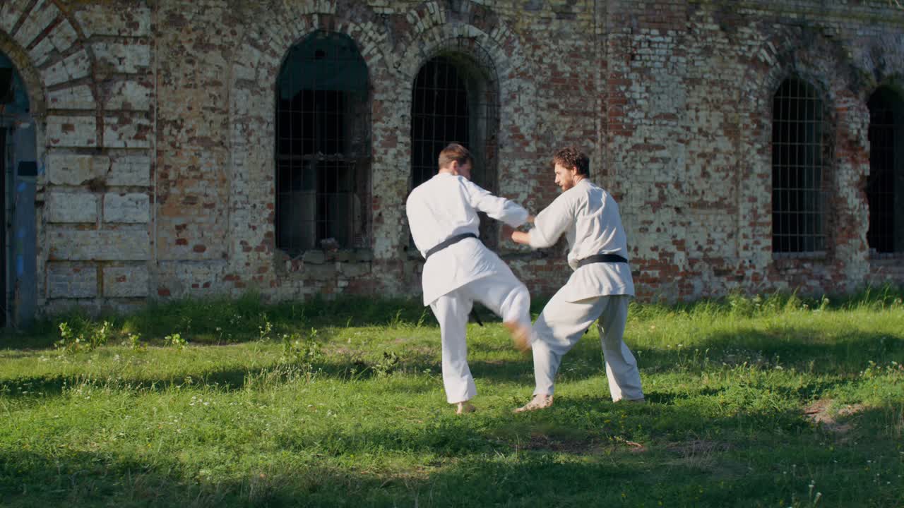 Due uomini che praticano karate all'aperto