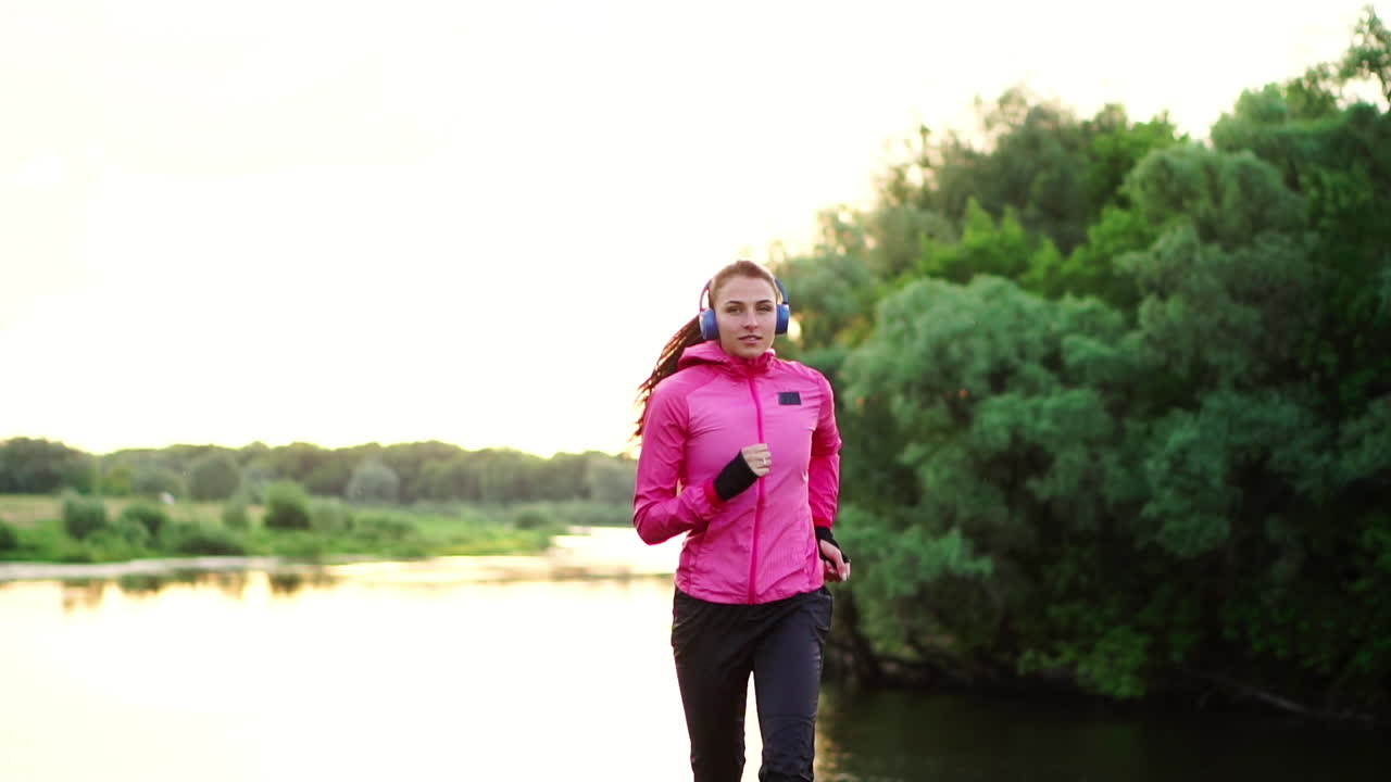 A morning jog in the Park near the pond in the Sunny rays of dawn, the girl is preparing to Mariano and lead a healthy lifestyle