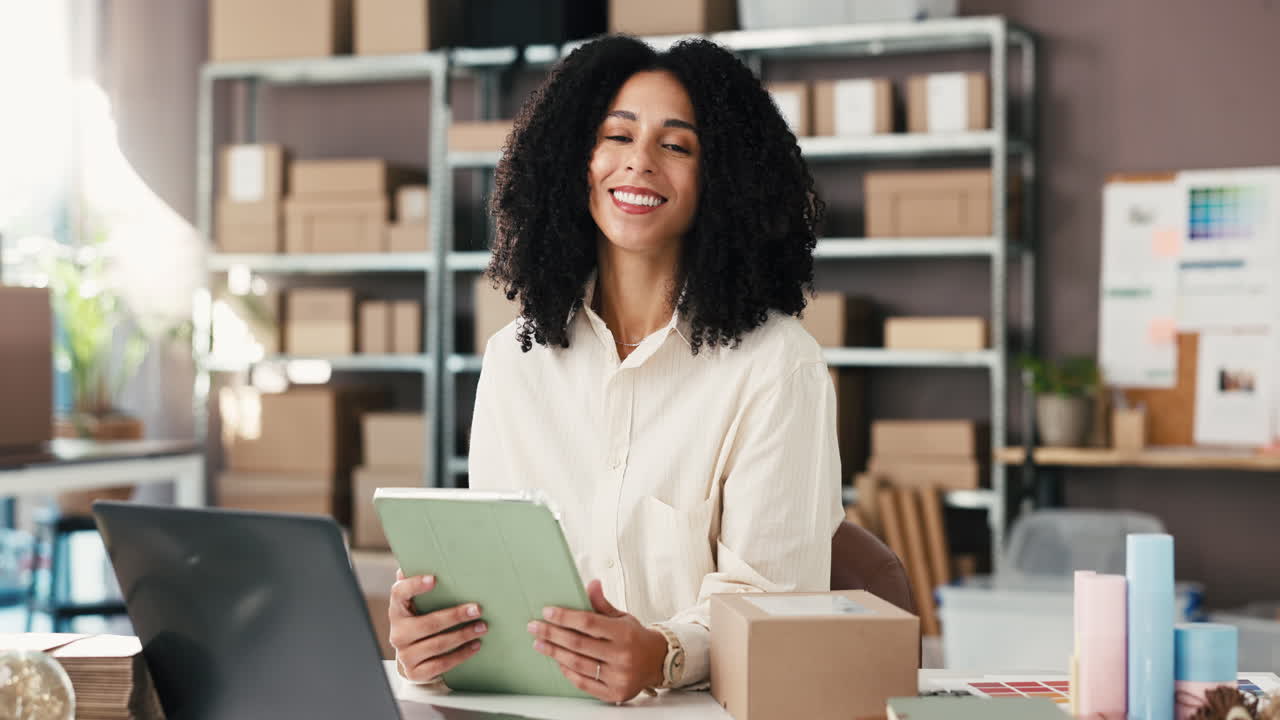 Imprenditrice felice che lavora con un tablet nell'ufficio di una piccola impresa