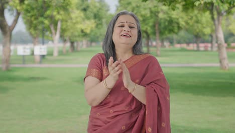 happy indian old woman clapping and appreciating in park