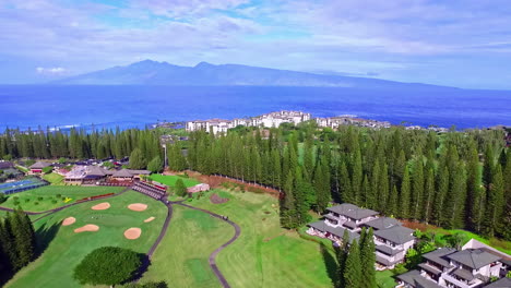 Aerial-view-of-luxury-resort-with-golf-court-and-sea-in-background-during-sunny-day---Beautiful-mountain-silhouette-in-backdrop---Hawaii-Pacific-Ocean