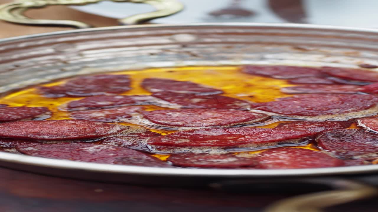 sucuk turco (salchicha picante) cocinado en una sartén de cobre