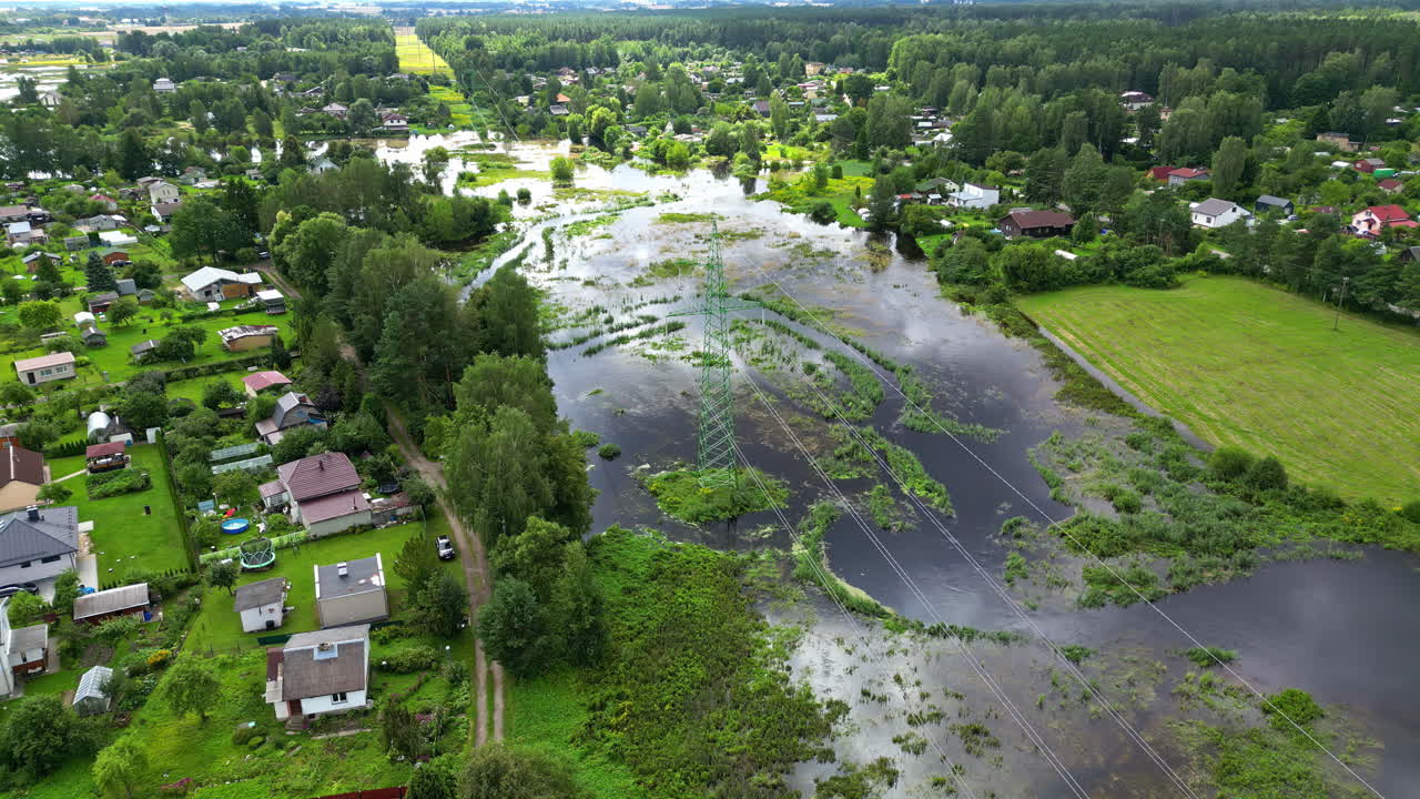 Suburban neighborhood heavily flooded by storm waters, affecting homes and green areas