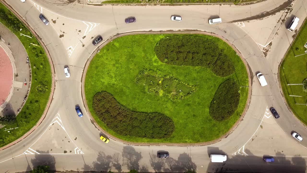 이동하는 자동차 교통과 함께 순환 거리의 교차로의 위에서 아래로 공중 전망.