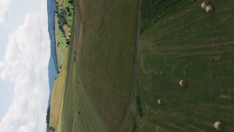 flyover above hay bales and farmland around delnita, romania