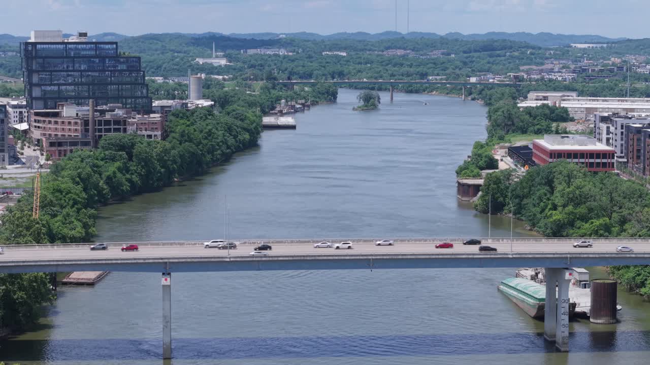 Static aerial view of a river, bridges, cityscape, and lush green surroundings over Cumberland River in Nashville, TNNashville