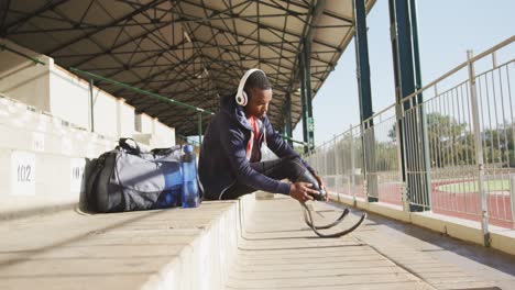 disabled mixed race man with prosthetic legs listening to music on headphones