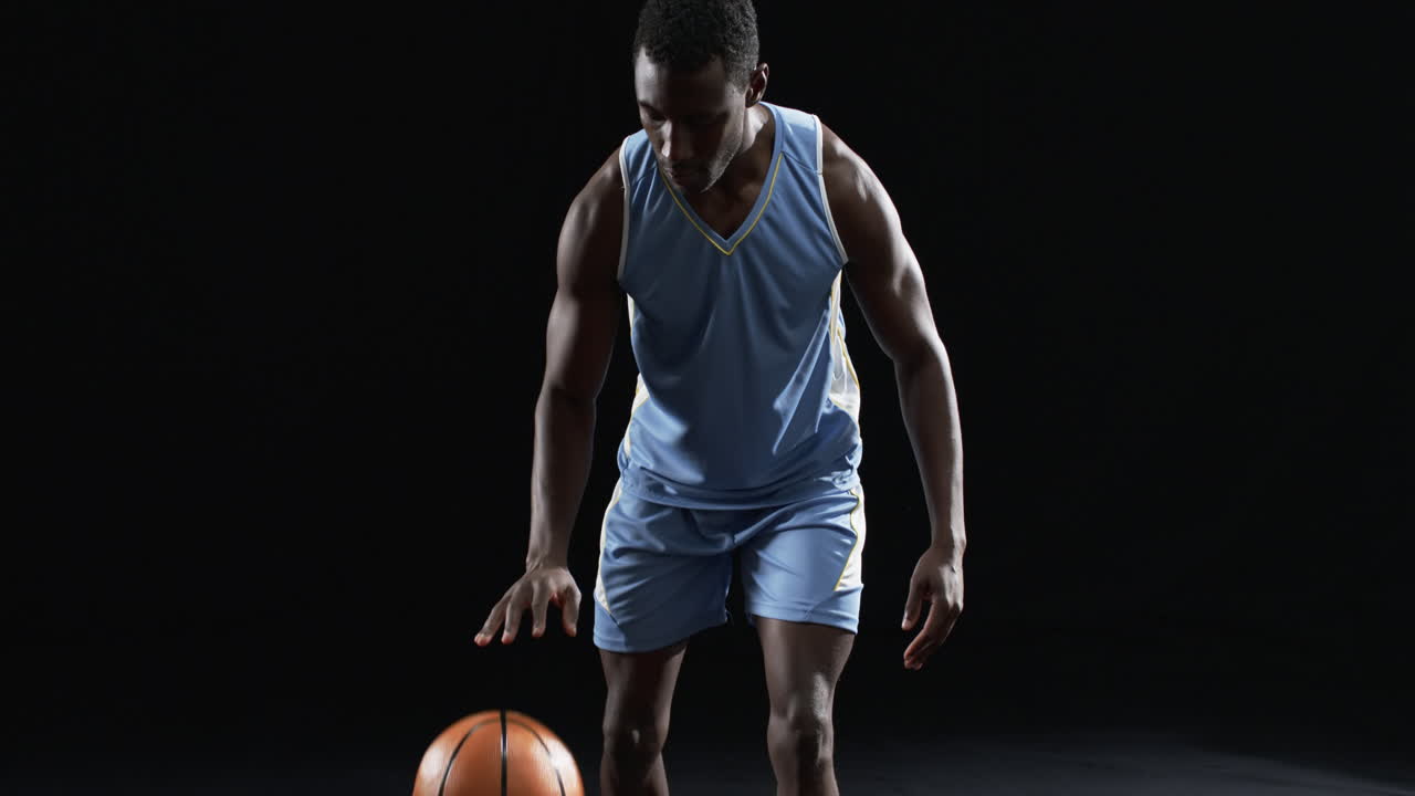 African American basketball player in a focused pose on a black background