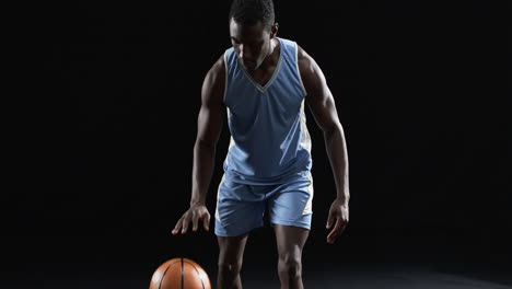 african american basketball player in a focused pose on a black background