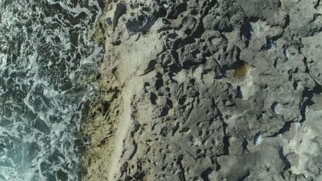 Topdown-view-along-Volcanic-rocky-coastline,-turquoise-water-color,-Hawaii