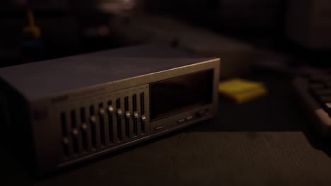 close up of a vintage audio device resting on a desk in a dimly lit room