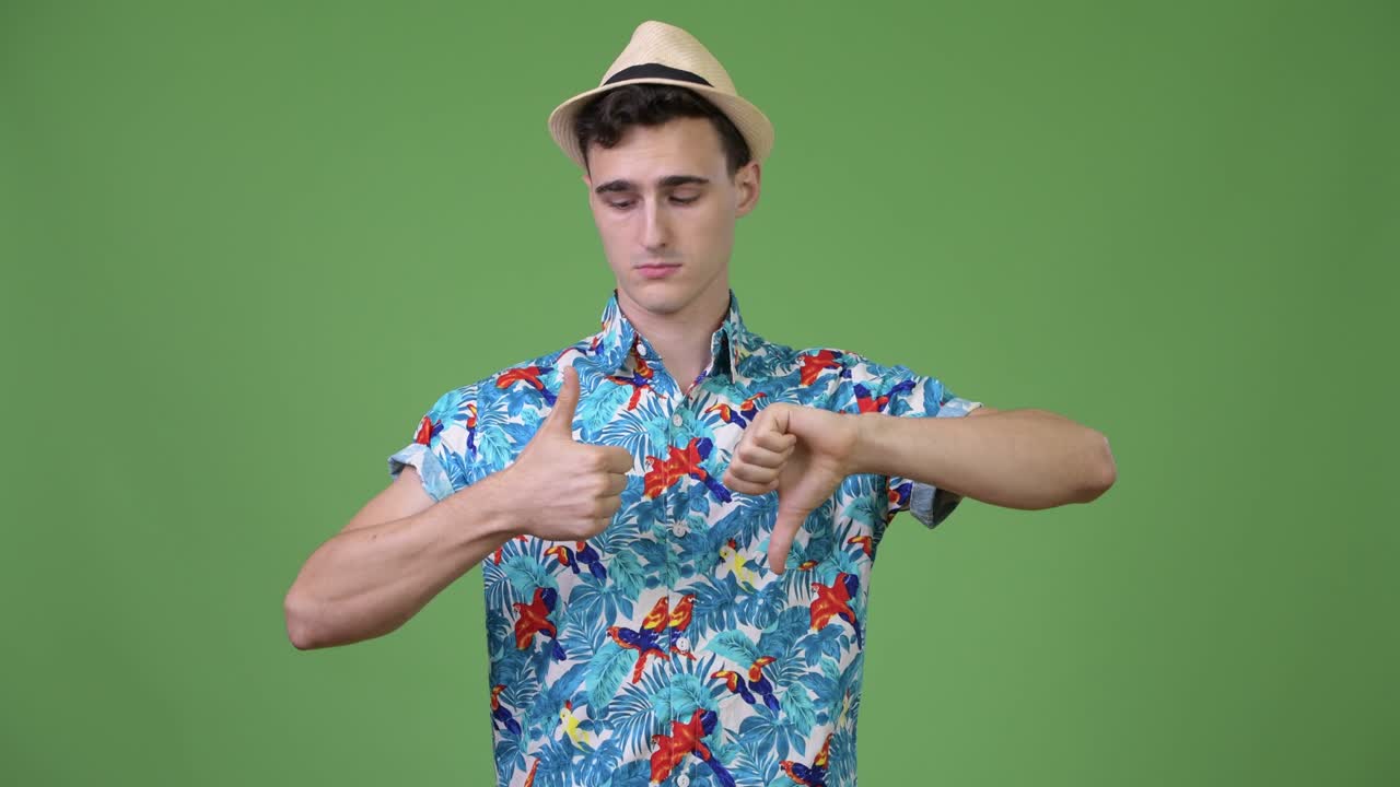 Young handsome tourist man choosing between thumbs up and thumbs down