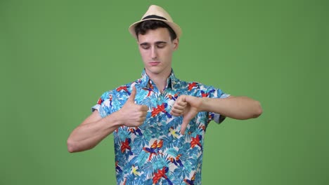 young handsome tourist man choosing between thumbs up and thumbs down