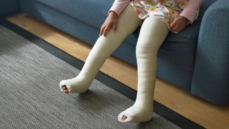 child with leg cast on sofa