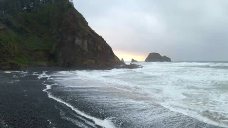 Rocky-beach-surrounded-by-cliffs-and-forest-in-Oregon-coastline-on-a-cloudy-day-aerial-view