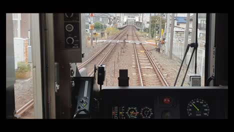 train ride through the suburbs of tokyo. video of the back of the train through the drivers window.