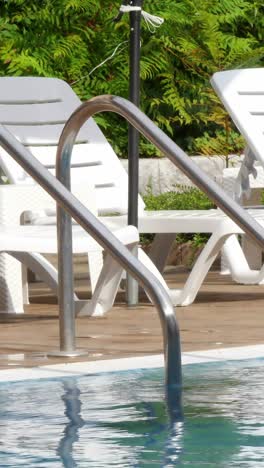 grab bars ladder in the blue swimming pool